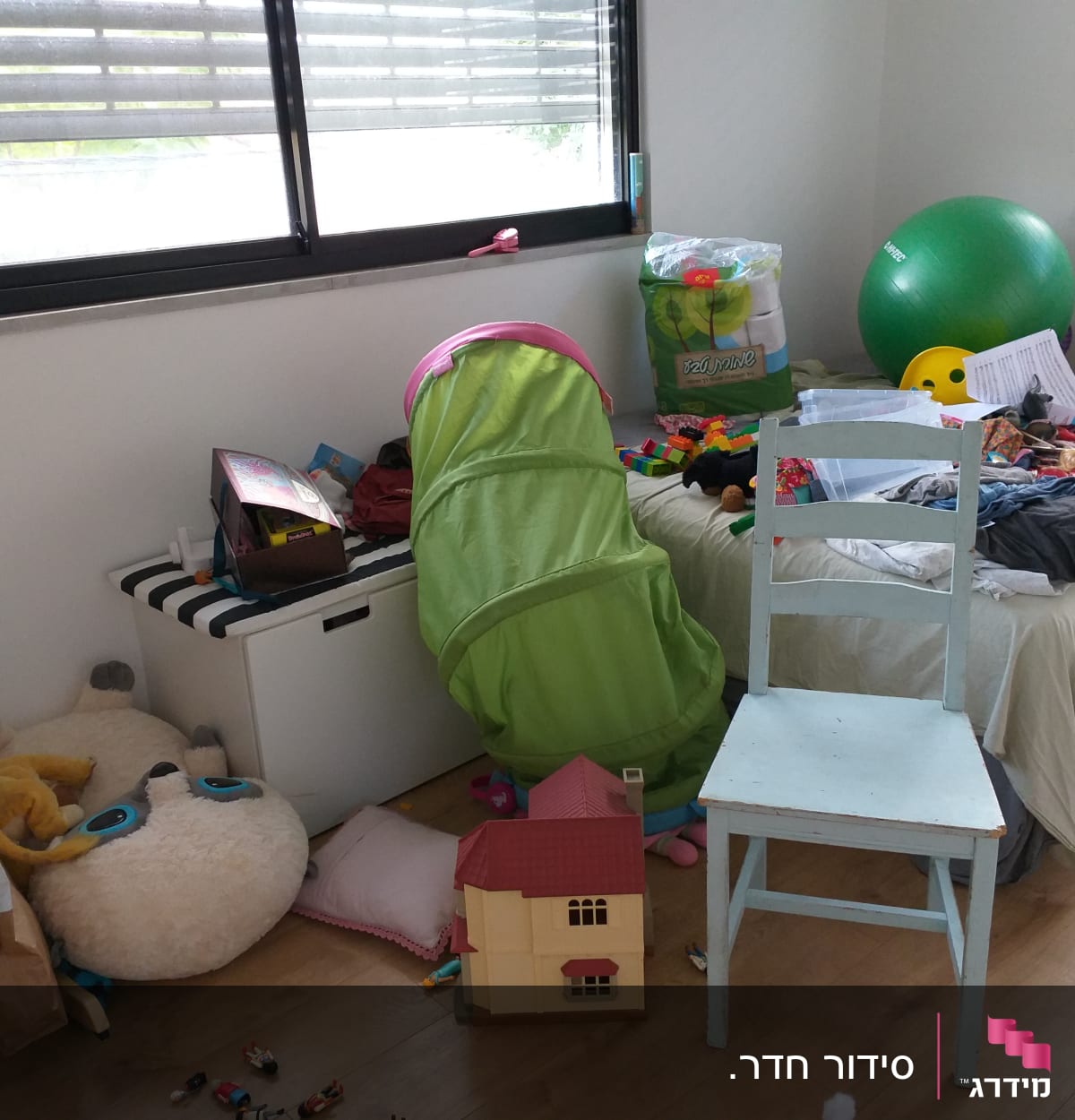 חדר מבולגן עם צעצועים, כדור ירוק, כיסא ומיטה